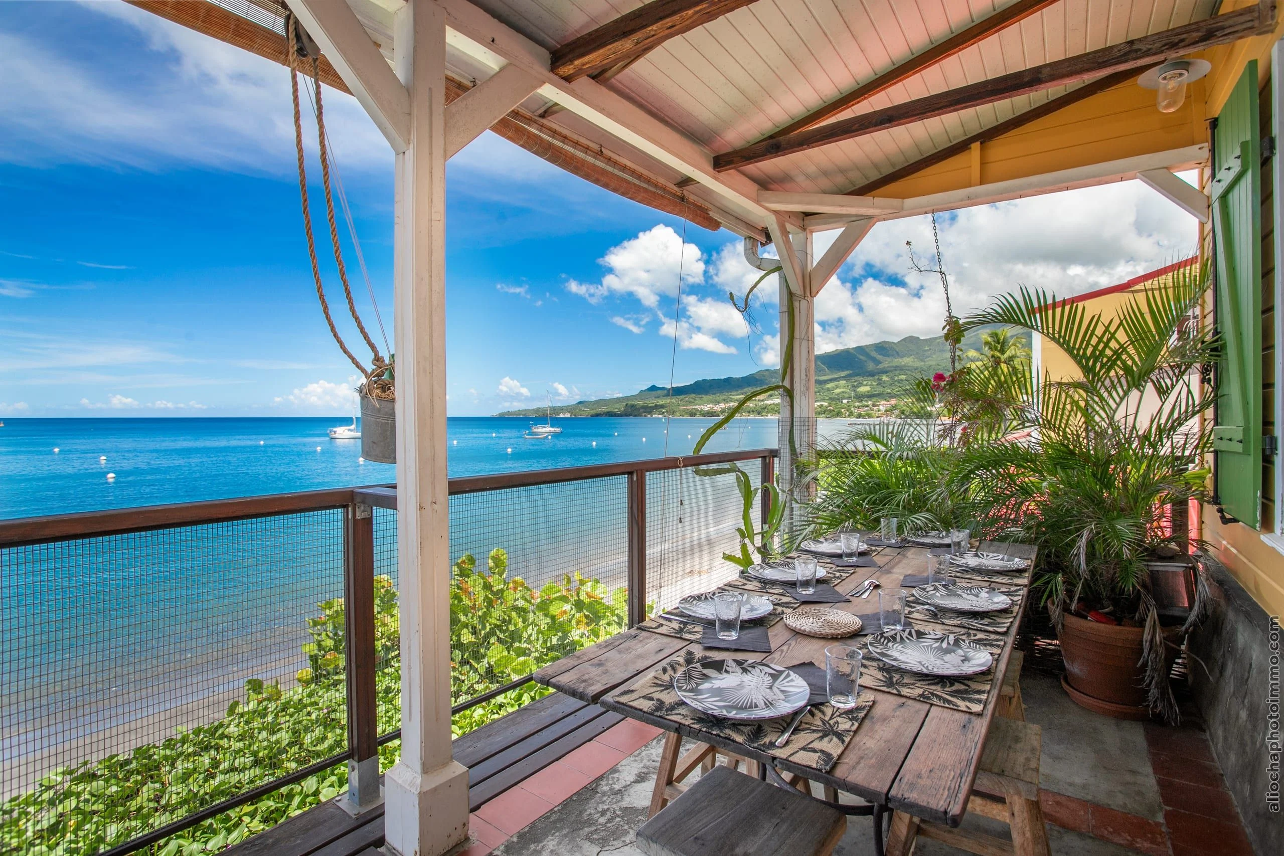 Grande terrasse avec table face à la baie de Saint-Pierre